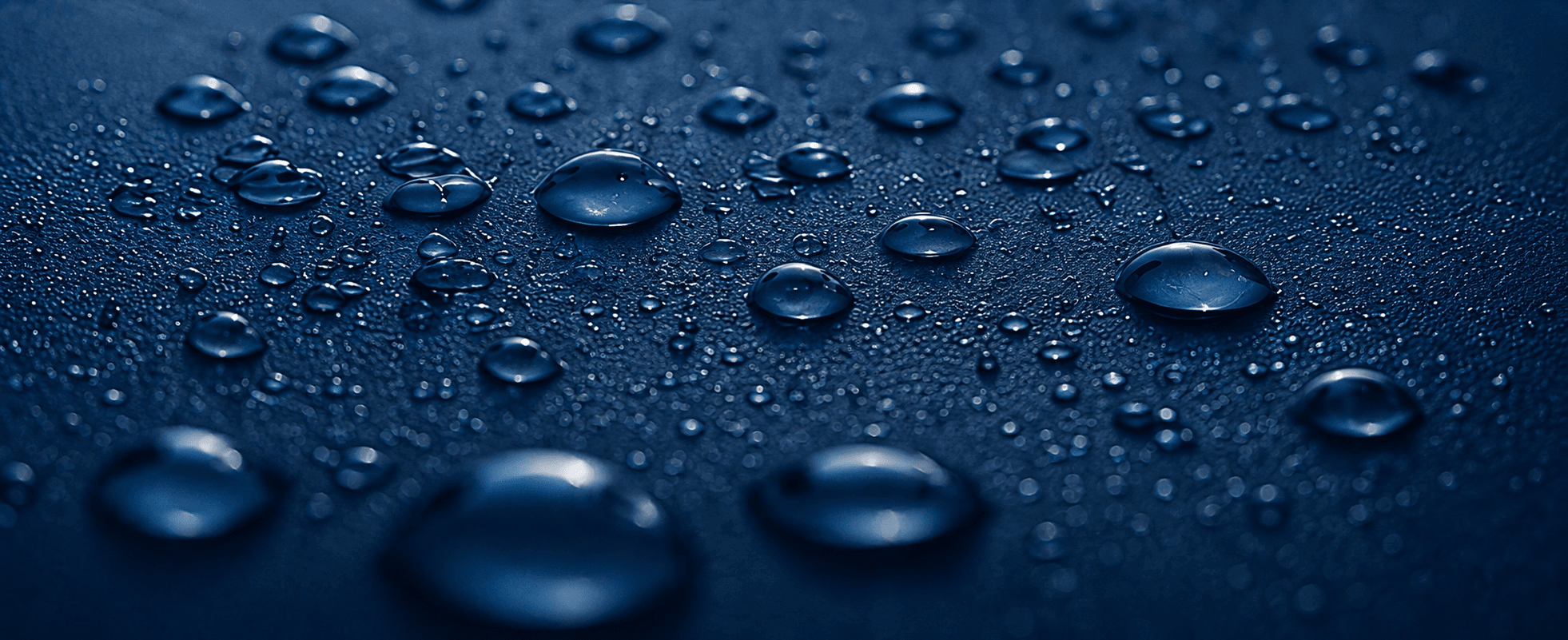 Gotas de agua pura sobre una superficie azul oscuro